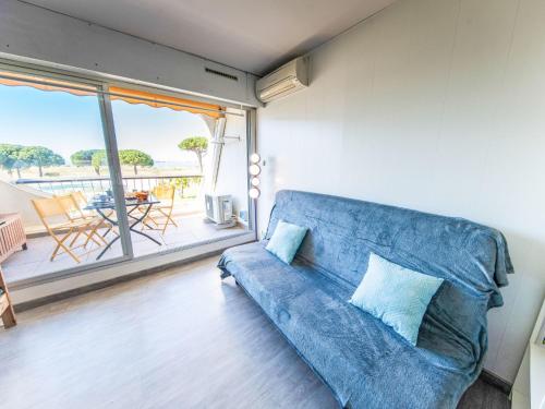 - un canapé bleu dans le salon avec balcon dans l'établissement Studio Escale Plage-3 by Interhome, au Grau-du-Roi