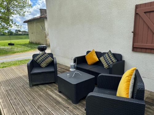 a patio with two couches and a table and chairs at Comfortable countryside gite access to jacuzzi in Asnois