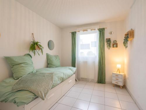 une petite chambre avec un lit et une fenêtre dans l'établissement Apartment Les Jardins d'Aunis-2 by Interhome, à Royan