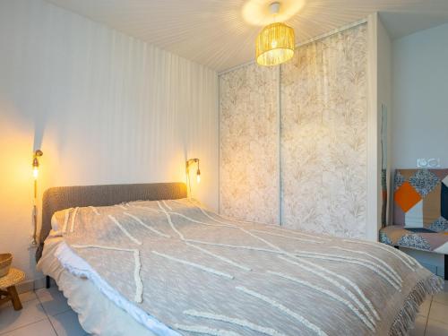 - une chambre avec un grand lit et un lustre dans l'établissement Apartment Les Jardins d'Aunis-2 by Interhome, à Royan