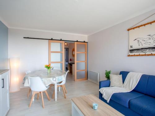 un salon avec un canapé bleu et une table dans l'établissement Apartment Les Tilleuls-3 by Interhome, à La Bernerie-en-Retz