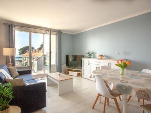 una sala de estar con una mesa y un sofá en Apartment Les Tilleuls-3 by Interhome, en La Bernerie-en-Retz