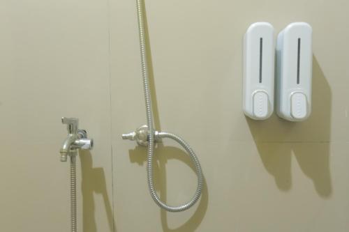 a bathroom with a shower with a shower head at Senaru Gateway homestay in Senaru