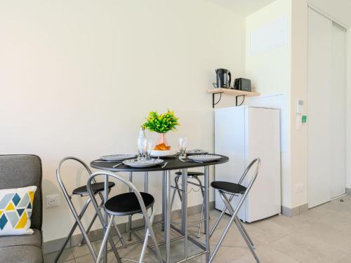 une cuisine avec une table avec des chaises et un réfrigérateur dans l'établissement Apartment Remember by Interhome, à Mimizan