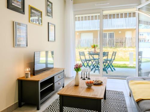 un salon avec une télévision et une table dans l'établissement Apartment Remember by Interhome, à Mimizan