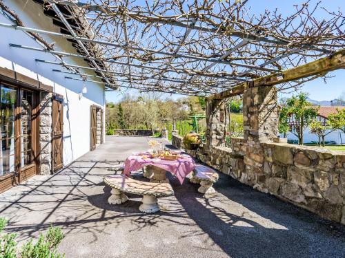 une table assise sous une pergola avec une nappe rose dans l'établissement Holiday Home Ederrenea by Interhome, à Urrugne
