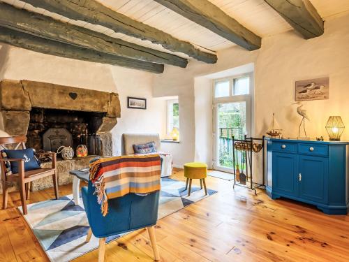 a living room with a stone fireplace and blue cabinets at Holiday Home Maison de Langonnet by Interhome in Langonnet