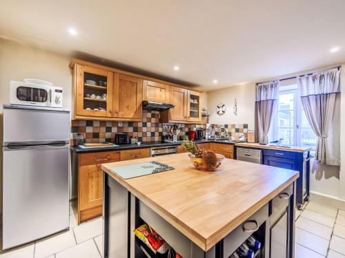a kitchen with a white refrigerator and a wooden counter top at Holiday Home Maison de Langonnet by Interhome in Langonnet