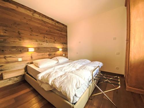 un lit dans une chambre avec un mur en bois dans l'établissement Apartment Les Grands Balcons by Interhome, aux Houches