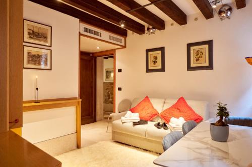 a living room with a white couch and red pillows at Nama Boutique Residence in Venice
