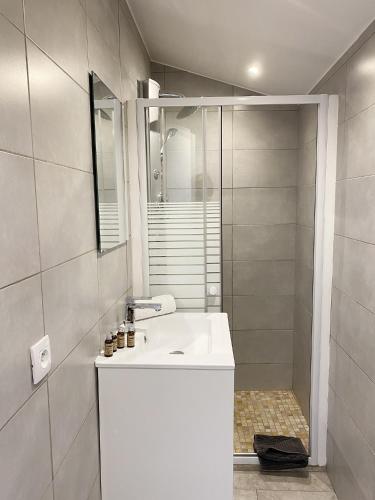 une salle de bain blanche avec un lavabo et une douche dans l'établissement Antibes Bis, à Cannes