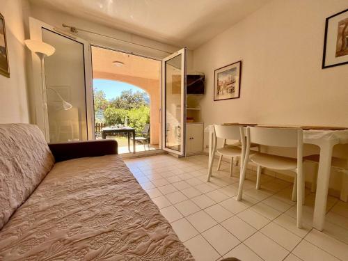 - un salon avec un lit et une table avec des chaises dans l'établissement Appartement avec terrasse et piscine, 2 pièces, 4 couchages, à Cavalaire-sur-Mer - FR-1-226B-206, à Cavalaire-sur-Mer