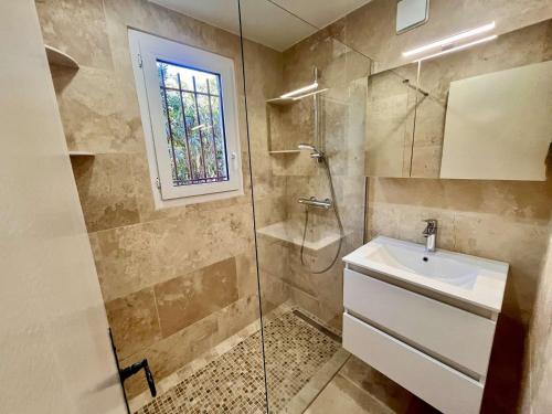 une salle de bain avec un lavabo et une douche en verre dans l'établissement Appartement avec terrasse et piscine, 2 pièces, 4 couchages, à Cavalaire-sur-Mer - FR-1-226B-206, à Cavalaire-sur-Mer