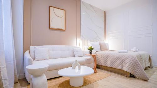 - un salon blanc avec un canapé et un lit dans l'établissement Modern Luxury Apartment Style & Serenity, à Paris