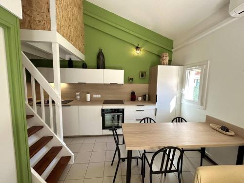 une cuisine avec des murs verts et une table et des chaises dans l'établissement Pavillon climatisé proche plage avec piscine à Argelès-sur-Mer - FR-1-388-227, à Argelès-sur-Mer