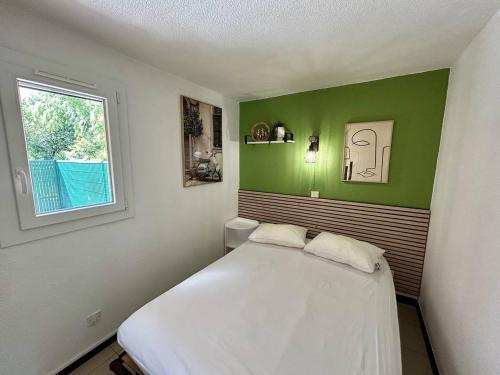 une chambre avec un lit blanc et une fenêtre dans l'établissement Pavillon climatisé proche plage avec piscine à Argelès-sur-Mer - FR-1-388-227, à Argelès-sur-Mer