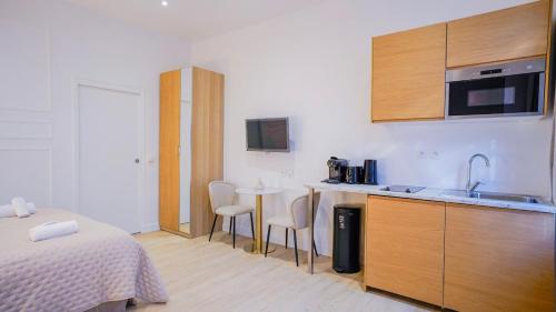une chambre avec un lit et une cuisine avec une table dans l'établissement Modern Luxury Apartment Style & Serenity, à Paris