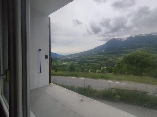 une fenêtre ouverte avec vue sur une montagne dans l'établissement Cocon au milieu des montagnes, à Saint-André-dʼEmbrun