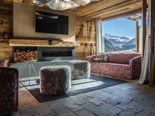 Una sala de estar con sofás, televisión y chimenea. en Holiday Home The Peak-11 by Interhome, en Sölden