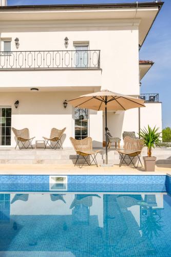 a villa with a swimming pool and a house at Vila sa bazenom Vrnjačka Idila in Vrnjačka Banja