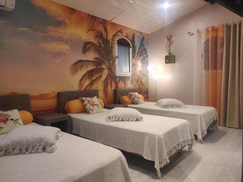 Villa Chantilly في سانت رافائيل: ثلاثة أسرة في غرفة مع لوحة جدارية على الحائط