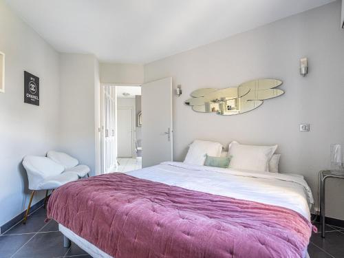 une chambre avec un grand lit avec une couverture violette dans l'établissement Apartment Le Clos Sainte Anne-2 by Interhome, à Saint-Tropez