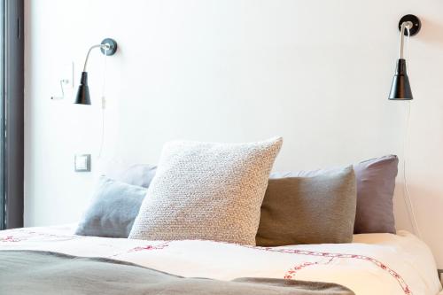 a bedroom with pillows on a bed with two lights at Junto a Rutas de Senderismo Dúplex con Vistas I AndBnB in El Tarter