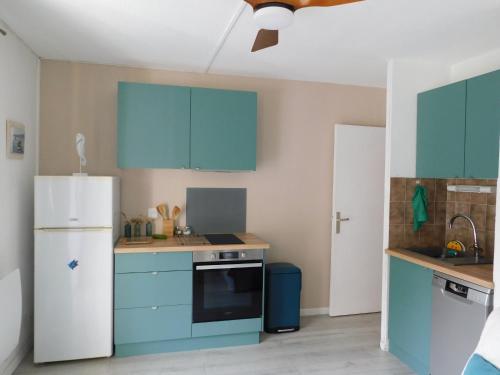 La cuisine est équipée de placards bleus et d'un réfrigérateur blanc. dans l'établissement Apartment le Verdon-5 by Interhome, à Six-Fours-les-Plages