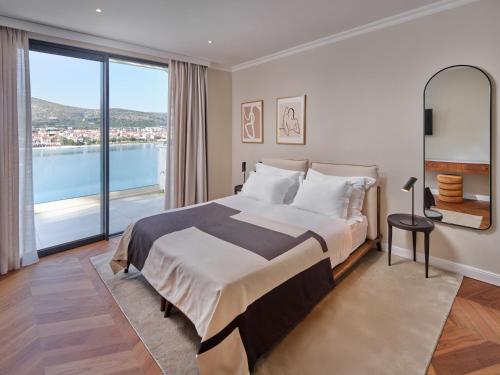 a bedroom with a large bed and a large window at Seaside Villa by Brown Hotels in Trogir