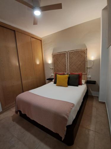 a bedroom with a large white bed with colorful pillows at Apartamento Ataraxia in Ronda
