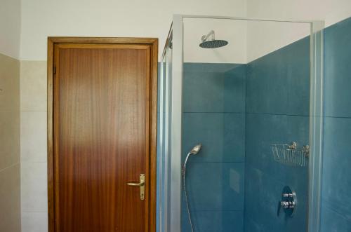 Un baño con ducha y puerta de madera. en Appartamento ristrutturato con piccola vista lago, en Besozzo