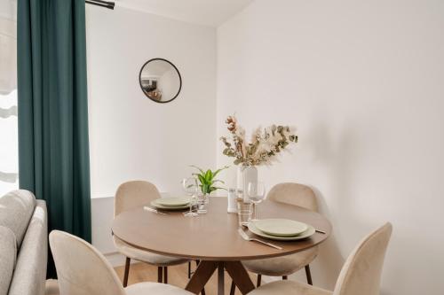 a dining room table with chairs and a round table with flowers at Le Reflet de Gambetta - Place Stanislas - 2 pers - Nancy Centre in Nancy