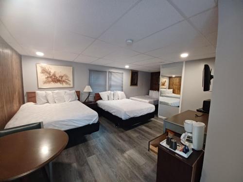 a hotel room with two beds and a table at Falls Motel in Niagara Falls