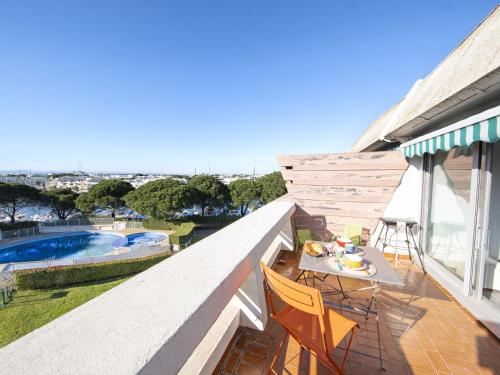 d'un balcon avec une table et des chaises, ainsi que d'une piscine. dans l'établissement Studio Le Quai aux Fleurs-7 by Interhome, au Grau-du-Roi