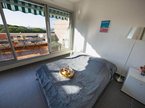 une chambre avec un lit et une grande fenêtre dans l'établissement Studio Le Quai aux Fleurs-7 by Interhome, au Grau-du-Roi