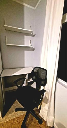 a desk with a chair next to a curtain at Apartamento Estocolmo I in Valdivia