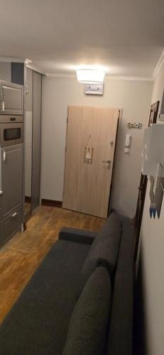 a living room with a couch in front of a door at Apartament L D Spa in Rewal
