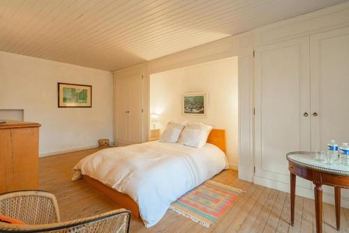 a bedroom with a large bed and a table at Maison Garesché - idéal télétravail & nature in Nieulle-sur-Seudre
