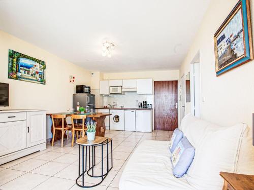 un salon avec un canapé blanc et une cuisine dans l'établissement Apartment Les Rives du Soleil by Interhome, à Canet