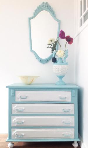 a dresser with a mirror and a vase with flowers on it at O Sardinhas in Matosinhos