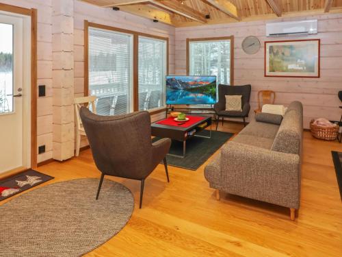 a living room with a couch and a table at Holiday Home Huvila tornionjoen rannalla by Interhome in Pello