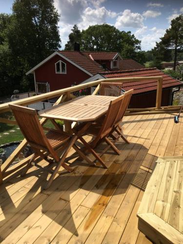 a wooden picnic table and two chairs on a deck at The Atte cottage in Sankt Anna