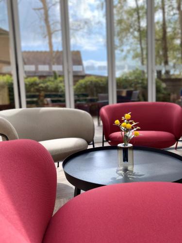 a room with chairs and a table with a vase of flowers at Holiday Inn Express Windsor by IHG in Windsor