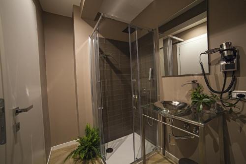 uma casa de banho com um chuveiro, um lavatório e um espelho. em Vatican Luxury Home em Roma