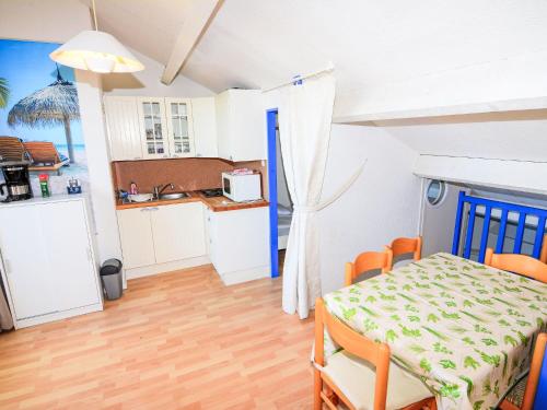 une cuisine et une salle à manger avec une table et des chaises dans l'établissement Apartment Coudalère-Guadeloupe-16 by Interhome, au Barcarès
