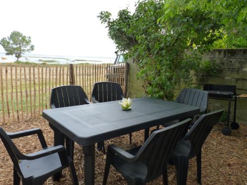 a black table and chairs with a flower on it at Villa MARGUERITE in Lacanau