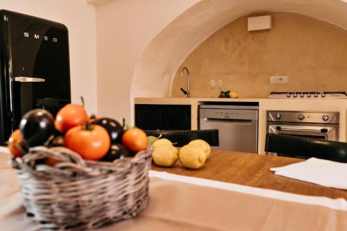 a kitchen with a basket of fruit on a table at Palazzo Pati in Tiggiano