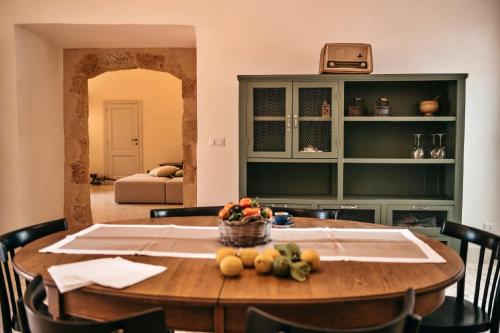 a dining room table with a bowl of fruit on it at Palazzo Pati in Tiggiano