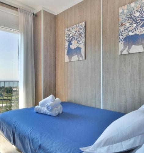 a bedroom with a blue bed with towels on it at Casa Marvista - piscina, barbacoa y vistas al mar in Pineda de Mar