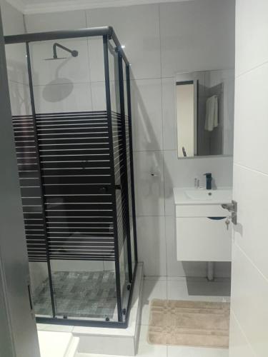 a bathroom with a glass shower and a sink at Hayat Hotel 94Juta in Johannesburg